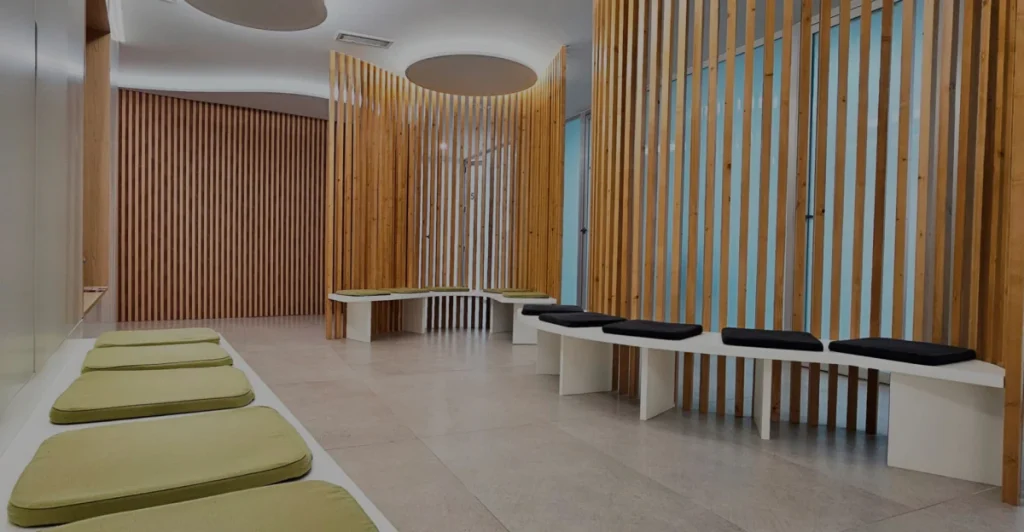 Sala de espera de Policlínica Venner con paneles de madera y bancos